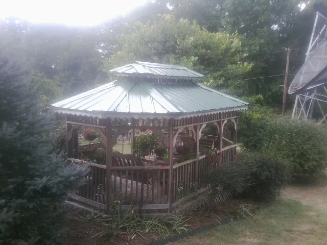 Green metal roof on a backyard gazebo surrounded by garden beds in Fairfield